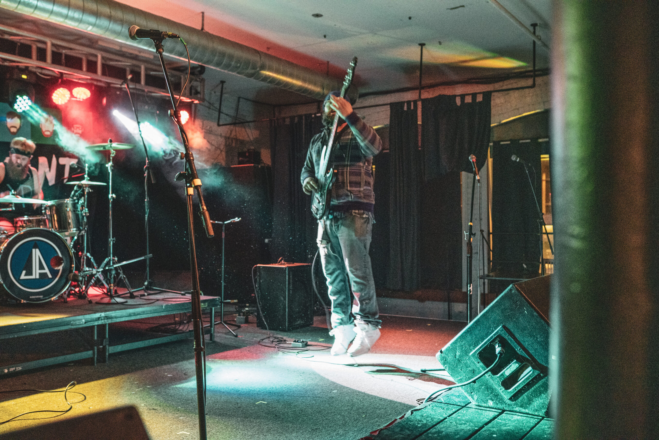 Jenn's Apartment performing at The Loft in Lansing, Michigan. Chris Davis is jumping in the air.